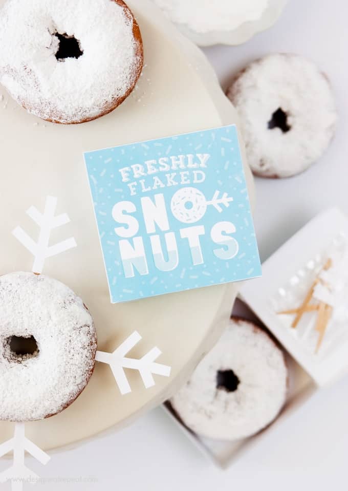 Freshly Baked Donuts? Pssh, how about Freshly Flaked Sno-Nuts! Download this free printable donut box kit from Design Eat Repeat for a fun addition to your holiday or Frozen party!