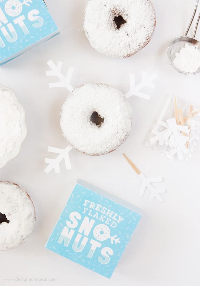 Freshly Baked Donuts? Pssh, how about Freshly Flaked Sno-Nuts! Download this free printable donut box kit from Design Eat Repeat for a fun addition to your holiday or Frozen party! So fun!