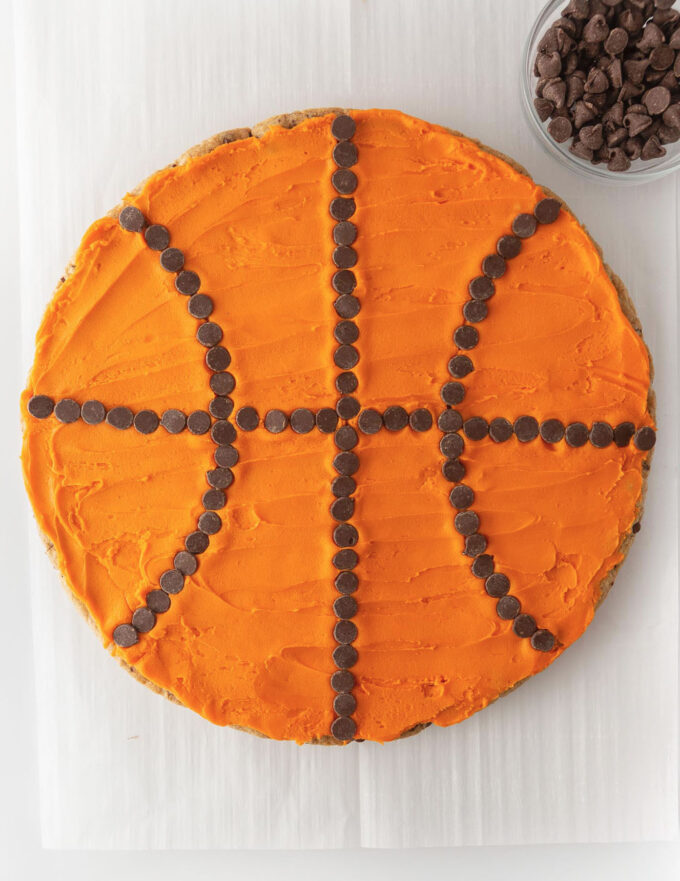 Decorated basketball cookie cake with orange frosting and chocolate chips