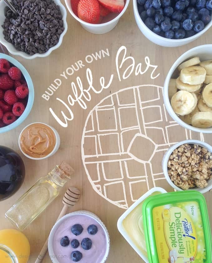 Ingredients and waffle toppings to create DIY Waffle Bar. Includes bowls of fruit, granola, yogurt, and chocolate chips.