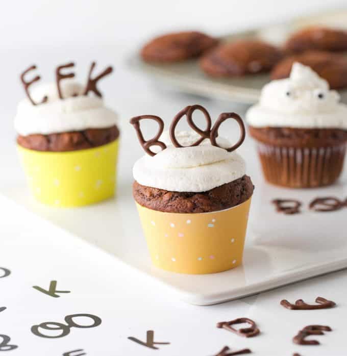 Cupcake topper made with chocolate that spells BOO with orange cupcake wrapper