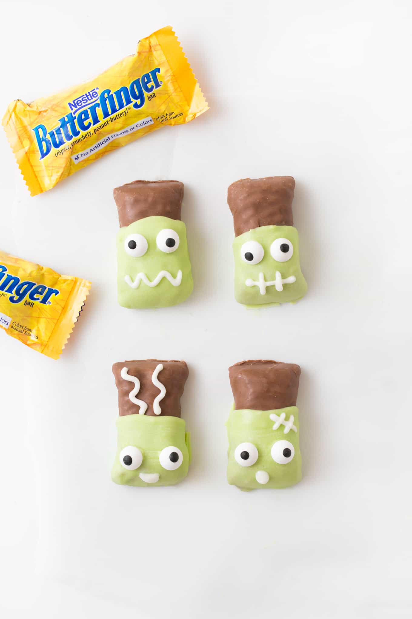 Butterfinger candy bars that have been dipped in melted green almond bark then decorated with candy eyeballs to look like Frankenstein and Frankenstein's bride.
