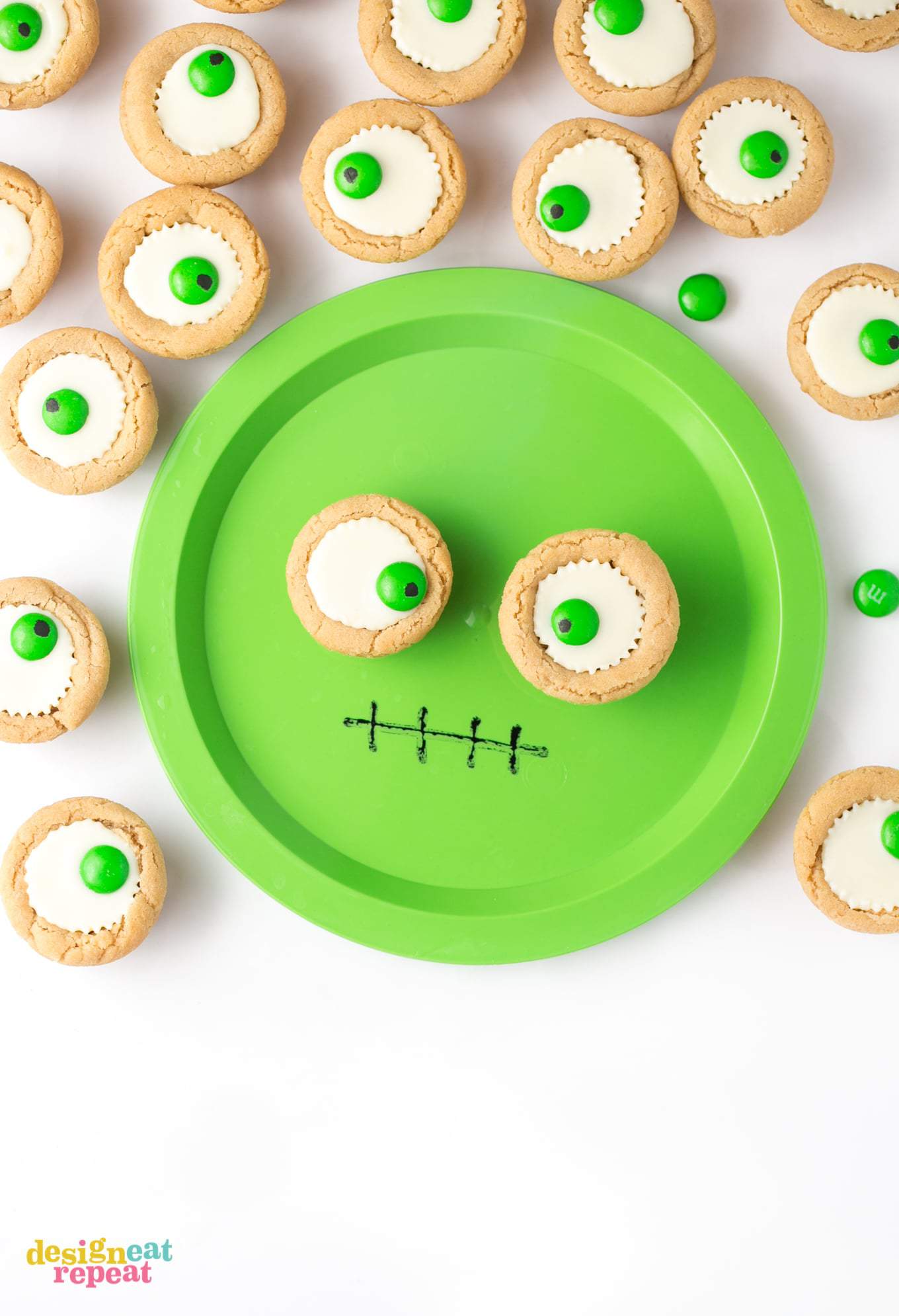 Mini white peanut butter cup cookies on green monster face plate.