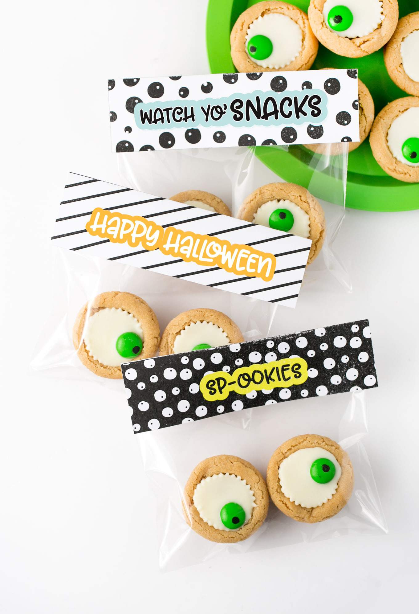 Easy Halloween Eyeball Cookies the kids can help with! After baking, simply press a miniature white peanut butter cup and M&M into the top of each one for a spooky (but cute!) halloween cookie idea.  #Halloween #Cookies #EyeballCookies | www.DesignEatRepeat.com