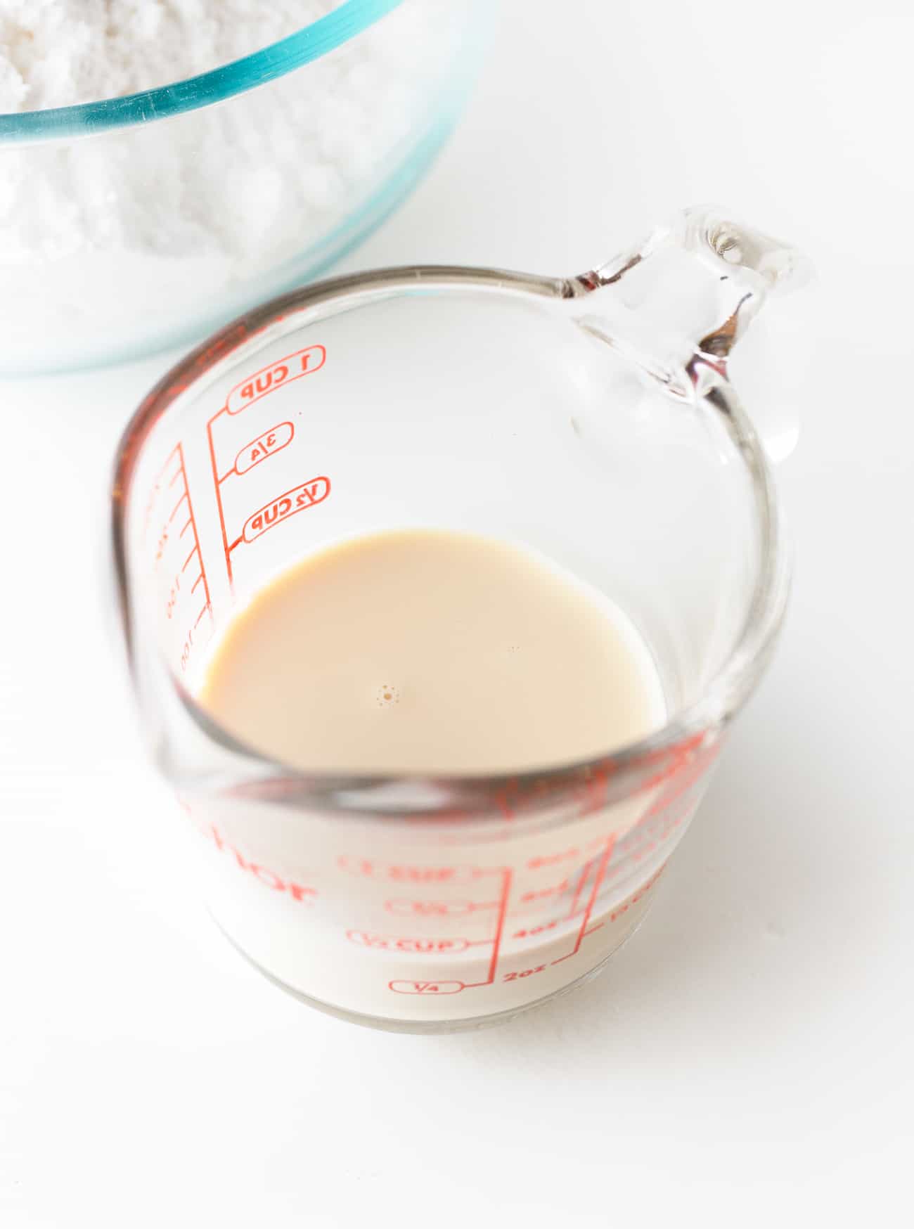 Pyrex glass measuring cup with evaporated milk to make fudgy, easy chocolate frosting.