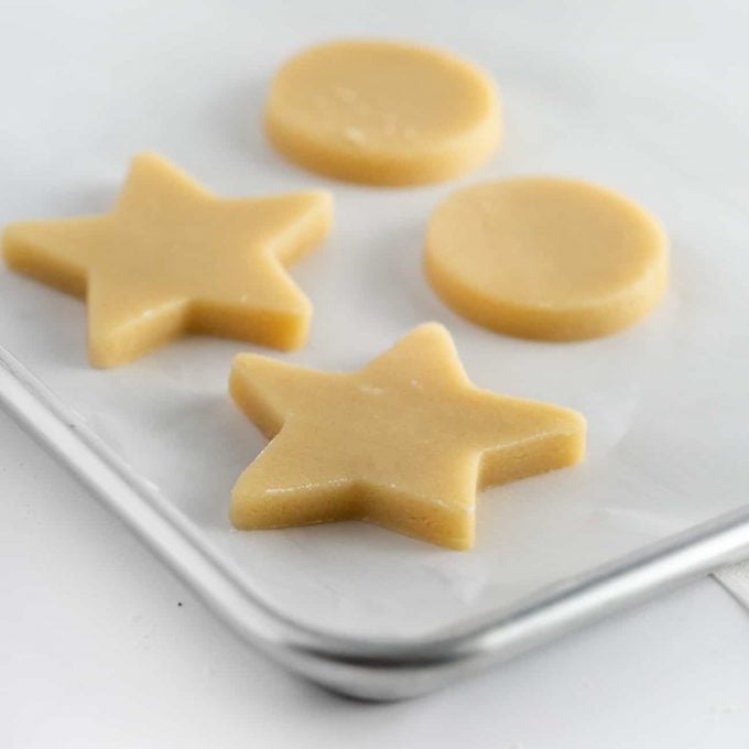 Star and circle shaped sugar cookie dough on baking tray
