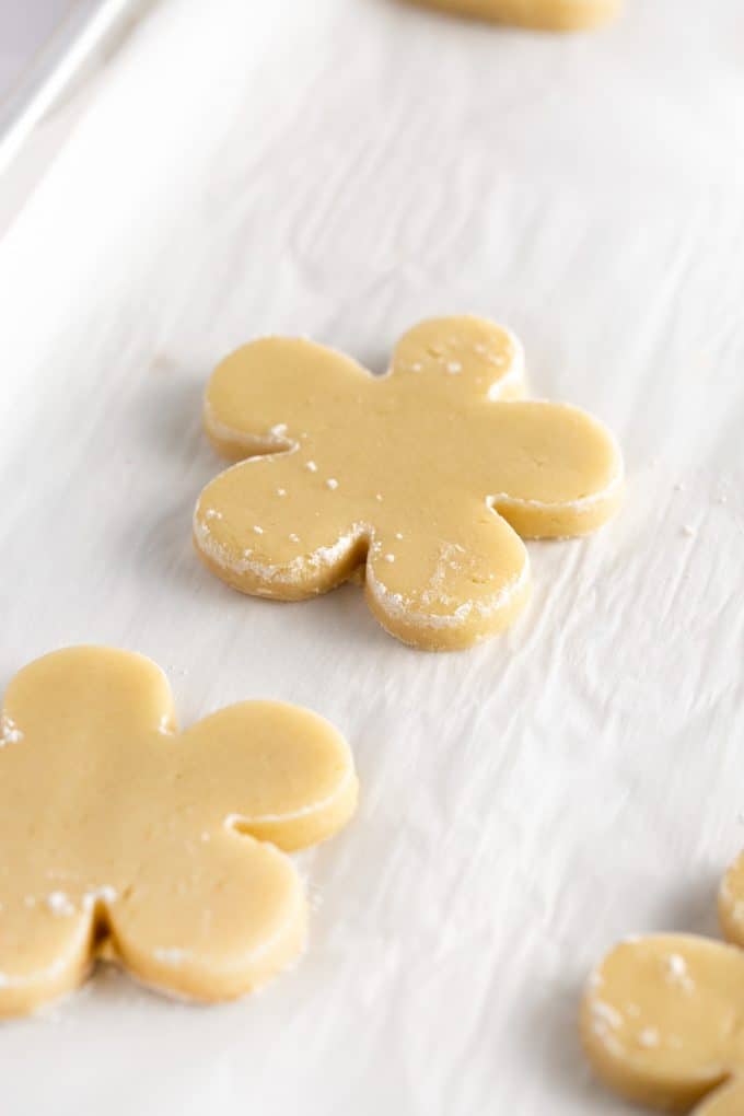 Flower shaped sugar cookie dough on baking tray