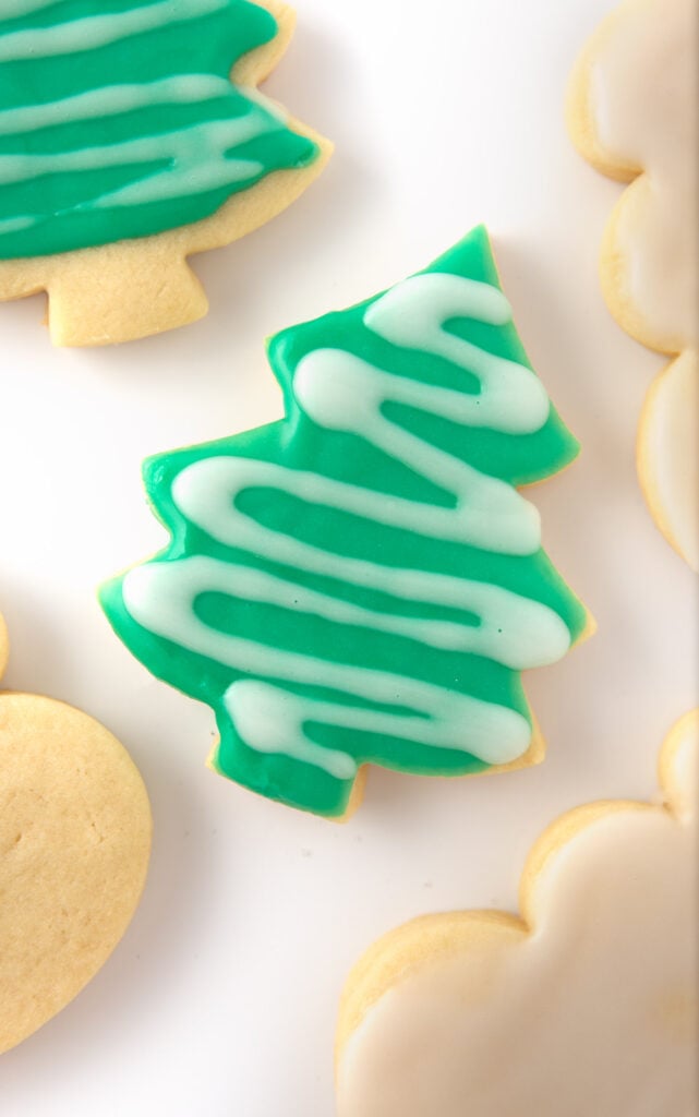 cut out christmas tree sugar cookies with green icing and white drizzle