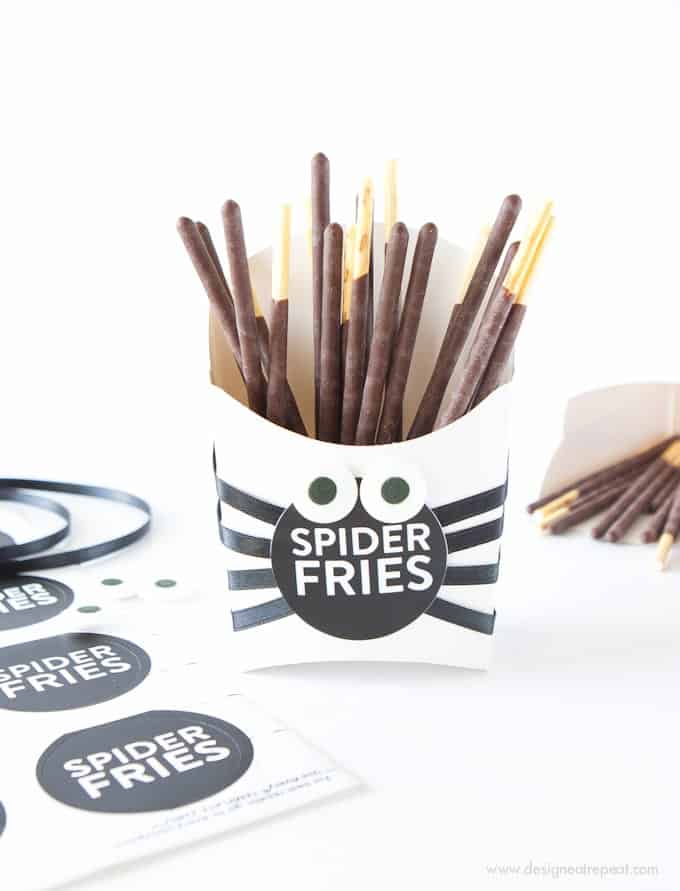 Make these DIY Spider Fry Boxes with paper fry boxes, pocky sticks, and free printable sticker labels! Designed by Melissa at @DesignEatRepeat blog!