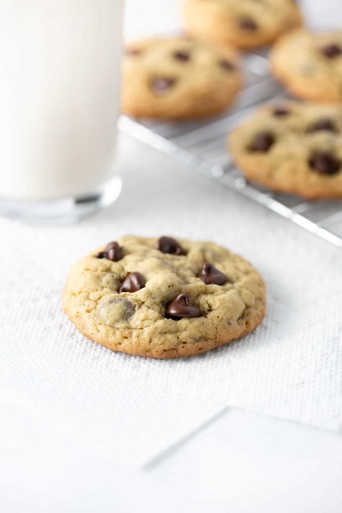 Warm chewy chocolate chip oatmeal cookie with glass of milk