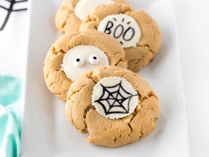 Peanut butter cookies with white chocolate reeses peanut butter cup, drawn on with black food marker. Spider web, eyeballs, and BOO.