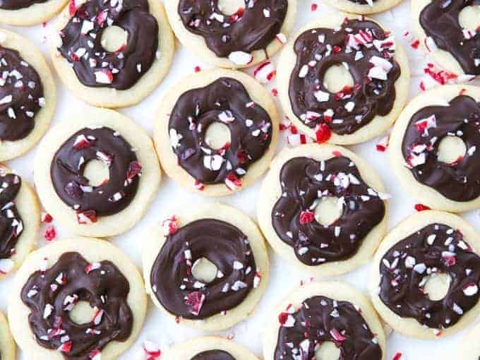 Peppermint cookies with chocolate and crushed peppermint bits on top in shape of donuts.