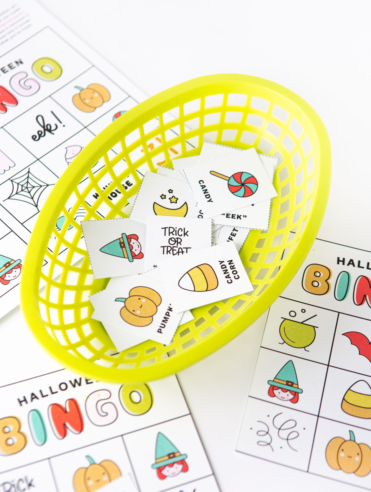 Basket of Halloween bingo cards calling cards with icons and pictures: pumpkin, witch, lollipop, cauldron, spider, ghost