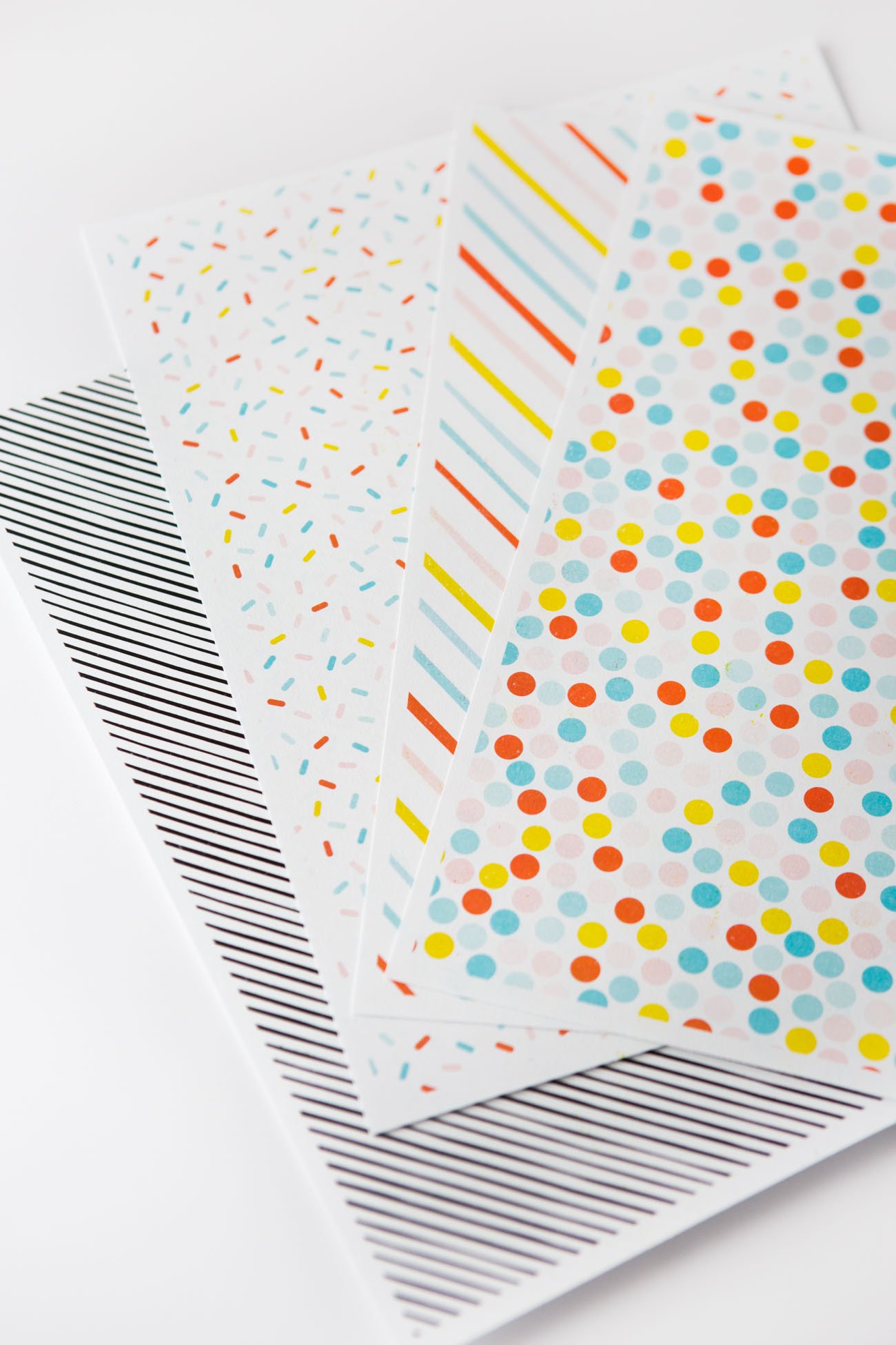 Rainbow printable scrapbook paper in sprinkle pattern, stripe, polka dot, and black and white stripe