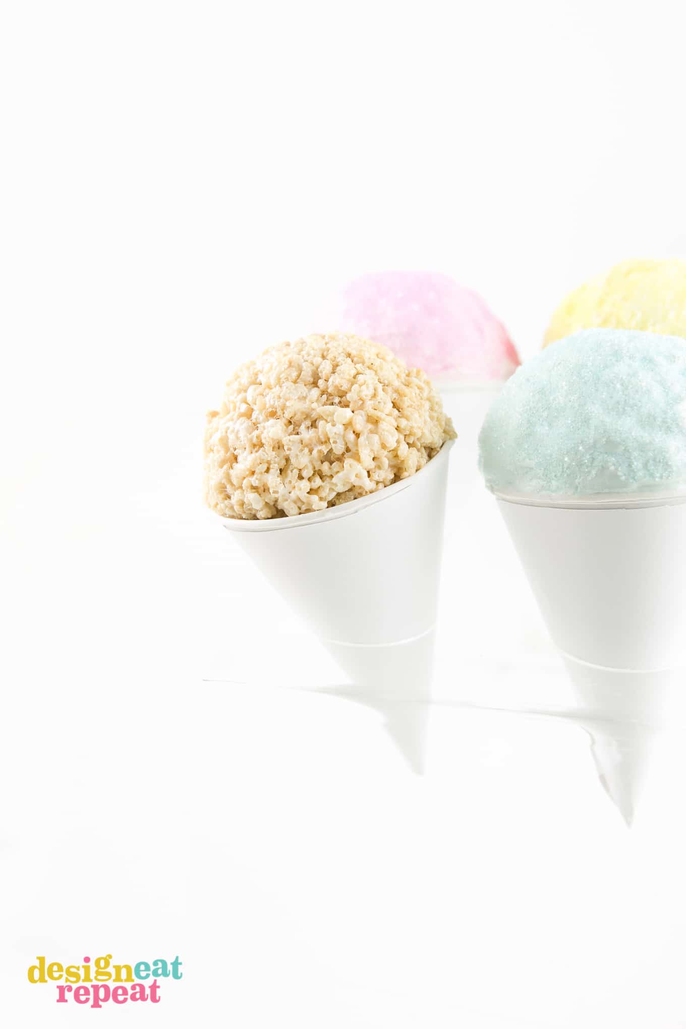 Ball of rice krispie cereal in paper snow cone with colored sugar.