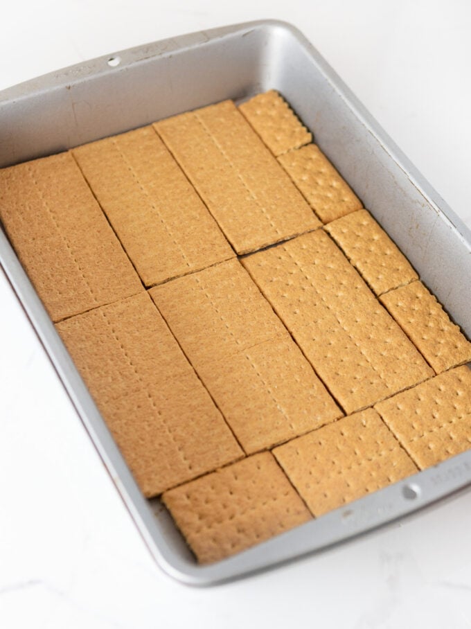 graham crackers lining bottom of 9x13 pan