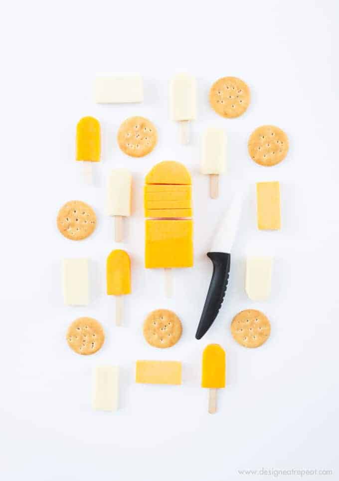 Turn cheese slices into mini popsicles with this fun cheese board idea! Fun way to mix up the Superbowl or holiday cheese tray!
