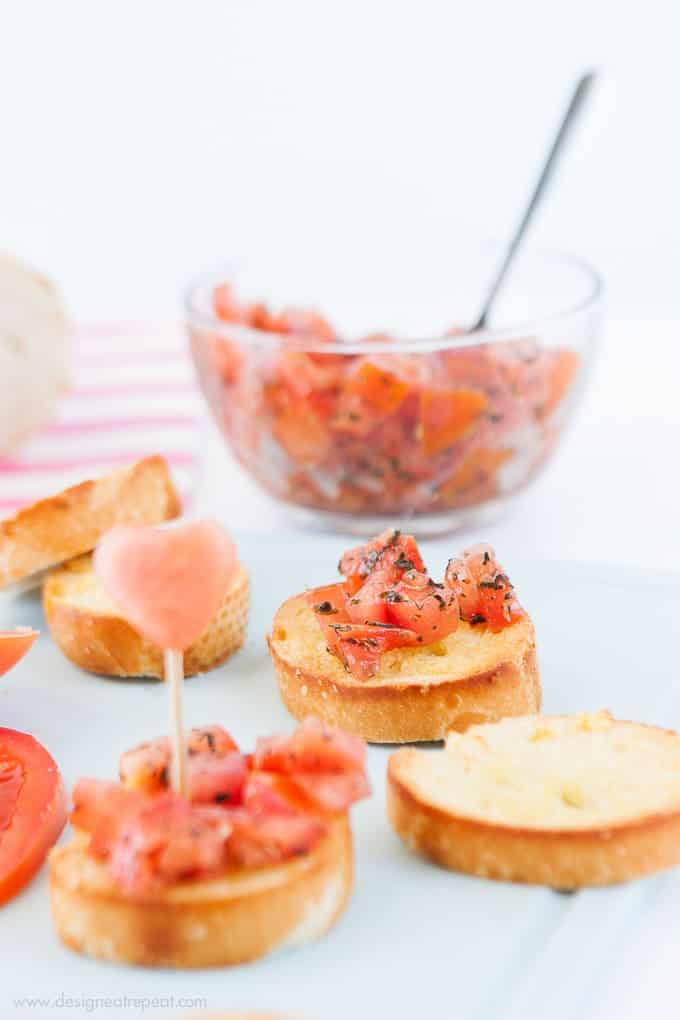 Use a mini heart cookie cutter to turn ordinary bruschetta into a festive Valentine's appetizer! Check out the recipe on Design Eat Repeat blog!