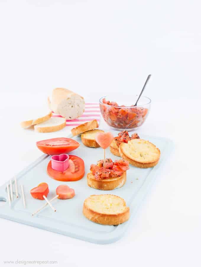 Use a mini heart cookie cutter to turn ordinary bruschetta into a festive Valentine's appetizer! Check out the recipe on Design Eat Repeat!